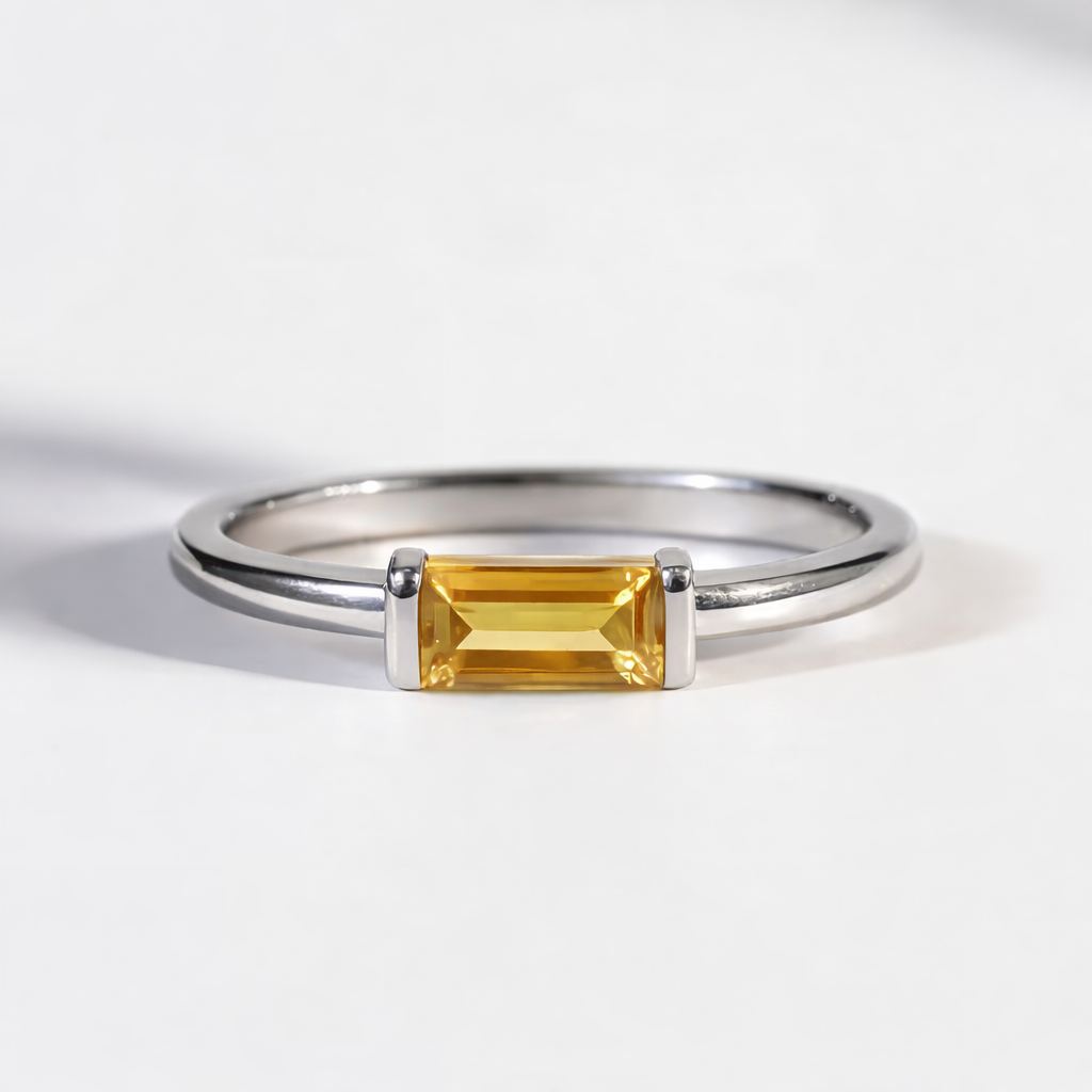Silver ring with a rectangular yellow  citrine gemstone on a white background