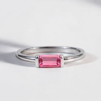 Silver ring with a pink gemstone on a light gray background
