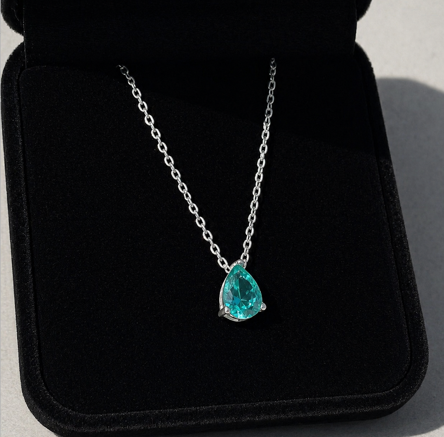 Paraiba Tourmaline Pear Cut Pendant Necklace on a black background