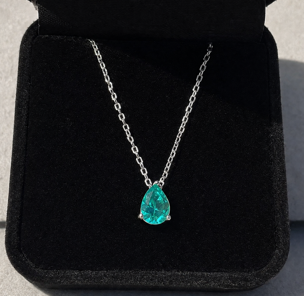 Paraiba Tourmaline Pear Cut Pendant Necklace on a black background