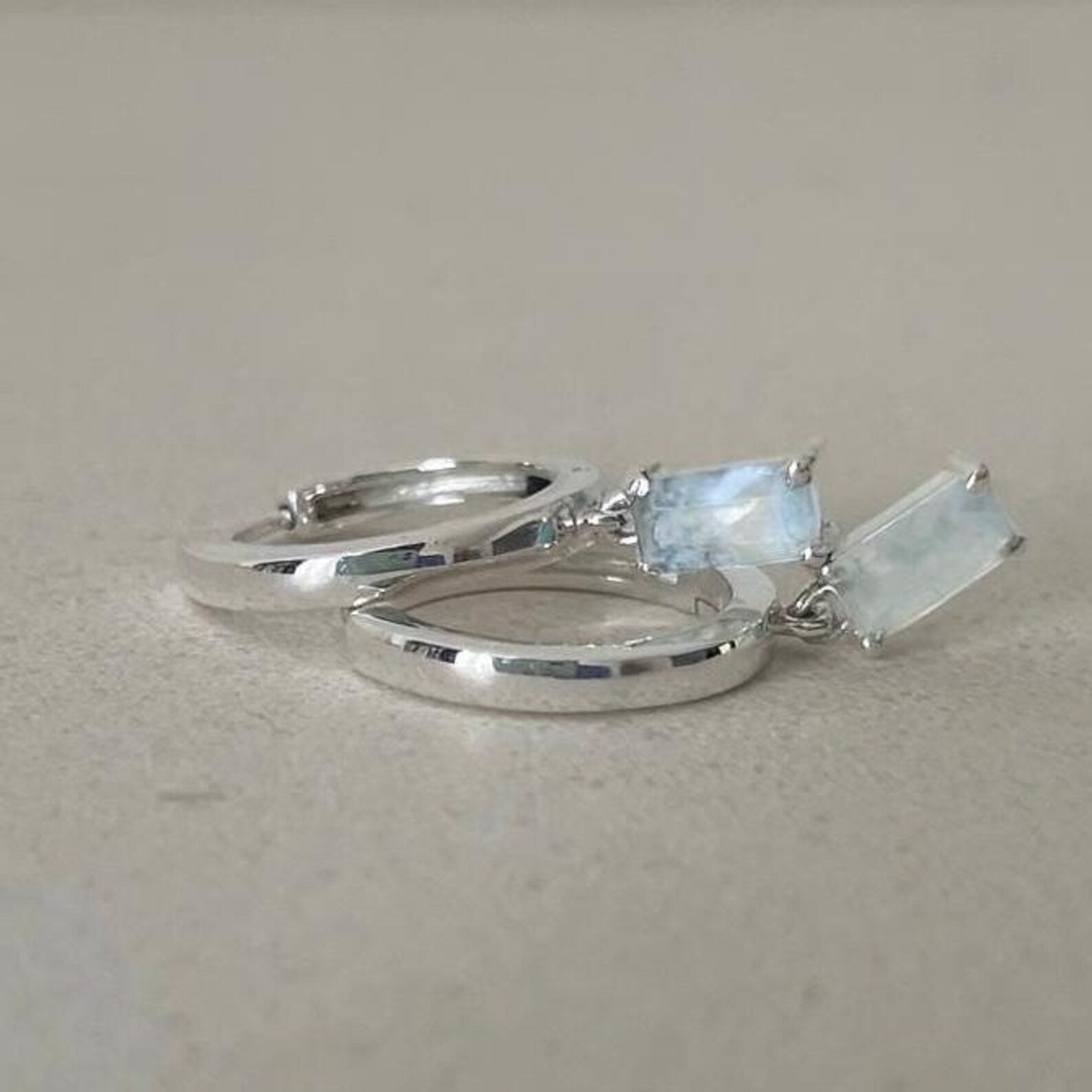 Silver ring with moonstone gemstones on a light gray background